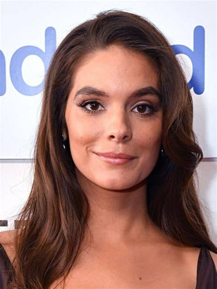 Actress, Caitlin Stasey giving a pose while wearing a white dress