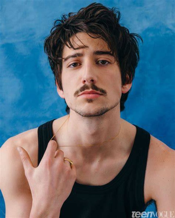 Milo Manheim in a black t-shirt and black pant.